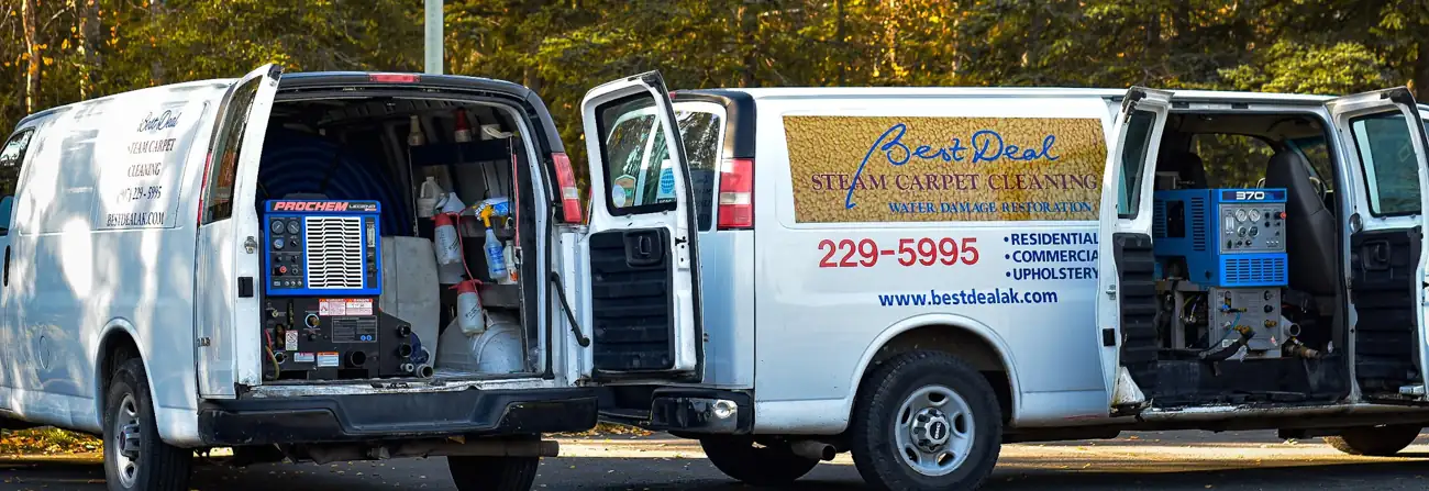 Two Best Deal vans with rear doors open showing Prochem truck-mount machines, ready for a job in Anchorage